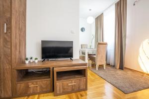 uma sala de estar com televisão num centro de entretenimento em madeira em Thomas Residence em Belgrado