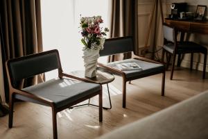 two chairs and a table with a vase with flowers at Hotel Majestic in Budva
