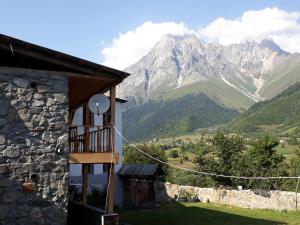 a house with a balcony and mountains in the background at Guest House Murkvam in Tvebishi