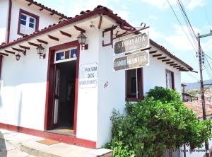 a white building with street signs in front of it at Pousada dos Bandeirantes in Ouro Preto +17 photos