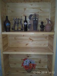 una estantería de madera con botellas y jarrones. en Kaxa Shorena Guest-House en Kazbegi