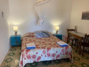 a bedroom with a bed and a desk and a table at Casa Mare Blu in Ginostra