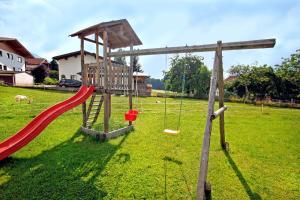 a playground with a red slide and a swing at Tuschnhof in Rinn