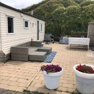 a patio with two white pots with flowers in it at Chalet De Duinberg in IJmuiden