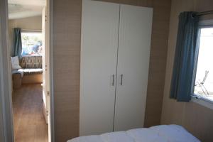 una camera con un letto e un grande armadio bianco di Chalet De Duinberg a IJmuiden