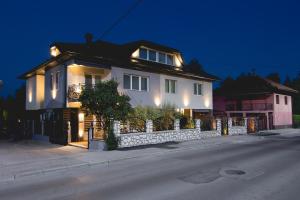 a white house with lights on the side of a street at APARTMENTS VRANAS in Visoko