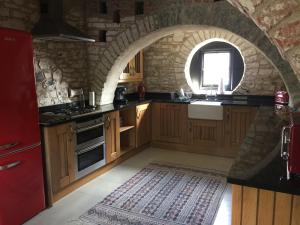 uma cozinha com um arco no meio em The Stable Loft, Llwynhelig Manor em Llandeilo