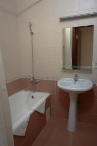 a bathroom with a sink and a bath tub next to a sink at Apart-Hotel Kurkino in Moscow