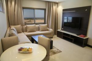a living room with a couch and a television at Emerald Residence in Yanbu