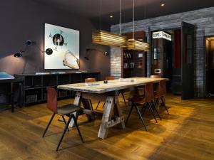 a dining room with a wooden table and chairs at 25hours Hotel Hamburg HafenCity in Hamburg