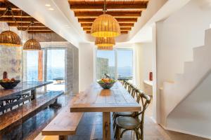 una sala da pranzo con tavolo e sedie in legno di Ria Mar Maria a Mykonos Città