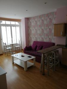 a living room with a purple couch and a table at Apartamentos San Roque in Ribadeo