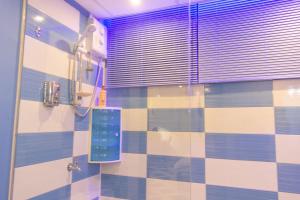 a bathroom with a shower with a tiled wall at Hotel Styled Apartment in Heart of Quatre Bornes in Quatre Bornes
