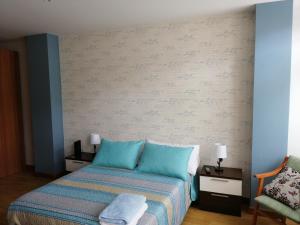 リバデオにあるApartamentos San Roqueのベッドルーム1室(ベッド1台、テーブル2台、椅子付)