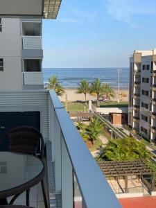 a balcony with a table and a view of the beach at Boulevard Family Club/ Bertioga - SP in Bertioga