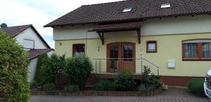 Maison jaune et blanche avec balcon dans l'établissement Ferienwohnung Trommblick - Natur Pur - Rimbach im Odenwald, à Rimbach