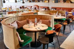a dining room with tables and chairs with wine glasses at Mama Shelter Lille in Lille