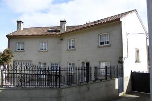 una casa con una valla negra delante de ella en Casa Reibon en Santiago de Compostela