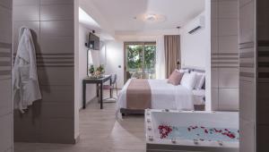 a bedroom with a bed and a bath tub with flowers in a bath tub at CHC Imperial Palace Adults Only in Adelianos Kampos