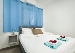 a bedroom with a bed with towels on it at Balfour sea view city center in Nahariyya