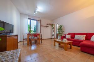 un soggiorno con divano rosso e tavolo di Luisa's House Bellagio a Bellagio