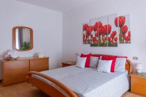 ベッラージョにあるLuisa's House Bellagioのベッドルーム1室(赤い枕と鏡付きのベッド1台付)