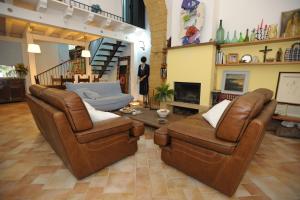 a living room with two leather chairs and a table at Arco Ubriaco in Agrigento