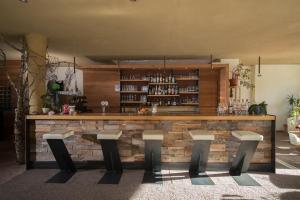 eine Bar mit vier Hockern in einem Zimmer in der Unterkunft Bike & Ski Hotel Diana in Welschnofen