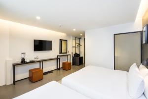 a bedroom with a bed and a tv on a wall at Marwin Space in Bangkok