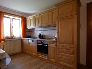 a kitchen with wooden cabinets and a stove top oven at Ferienwohnung Pfnür in Berchtesgaden