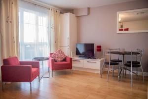 a living room with a table and chairs and a television at Holywell Way Swords in Cloghran