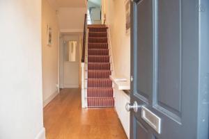 a hallway with a staircase with red stair risers at Rugby Lodge in Dublin