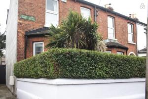 a hedge in front of a brick building at Rugby Lodge in Dublin