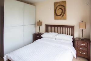 a bedroom with a large bed with white sheets and pillows at The Edges A2B in Sandyford