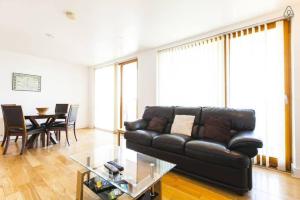 a living room with a black leather couch and a table at Grande Central in Dublin