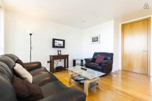uma sala de estar com um sofá de couro e uma mesa em Grande Central em Dublin