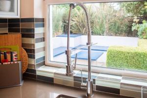 a kitchen sink with a faucet next to a window at Rugby Lodge in Dublin
