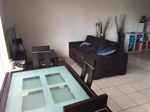 a living room with a couch and a glass table at Appart Thonon Corzent au bord du Lac in Thonon-les-Bains