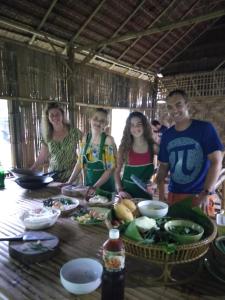 eine Gruppe von Menschen steht mit Essen um einen Tisch herum in der Unterkunft Meechok organic home in Ao Nang Beach + 50 Fotos