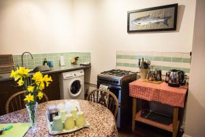 a kitchen with a table and a sink and a stove at Butlers Quarters Apartment in Cairndow