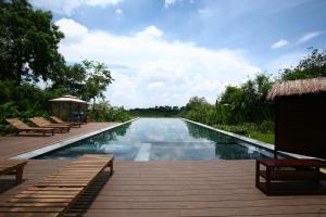 a swimming pool with a deck and chairs next to it at Tomodachi Retreat - Làng Mít in Sơn Tây