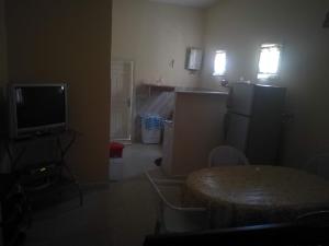 a room with a table and a kitchen with a television at studio climatise pour vacance in Ḩammām al Ghazzāz