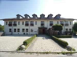una gran casa blanca con una entrada delante de ella en Wirtshaus Zur Bina, en Vilsbiburg