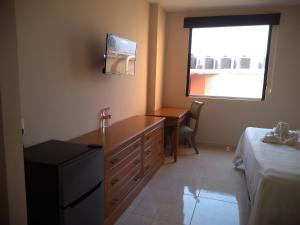 Schlafzimmer mit einem Schreibtisch, einem Bett und einem Fenster in der Unterkunft Hotel Del Viajero in Ciudad del Carmen