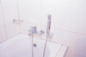 a shower with a hose in a white bathroom at High Tide in Amanzimtoti +49 photos