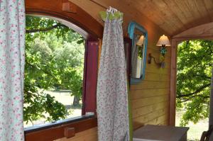 una tenda appesa a una finestra in una stanza di La roulotte Chic et Boheme a Mazan