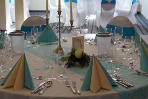 einen Tisch mit Tellern und Weingläsern darauf in der Unterkunft Apartments Golfpark Schlossgut Sickendorf in Lauterbach