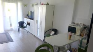 a kitchen with a table and a white refrigerator at Éva apartman in Balatonboglár