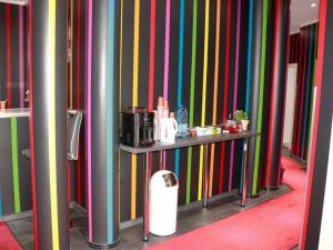 um quarto com paredes listradas coloridas e uma mesa com aperitivo em Amaya Motel em Berlim