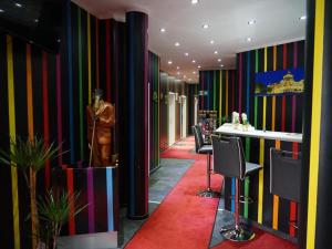 un pasillo colorido con un bar con sillas y un maniquí en Amaya Motel en Berlín